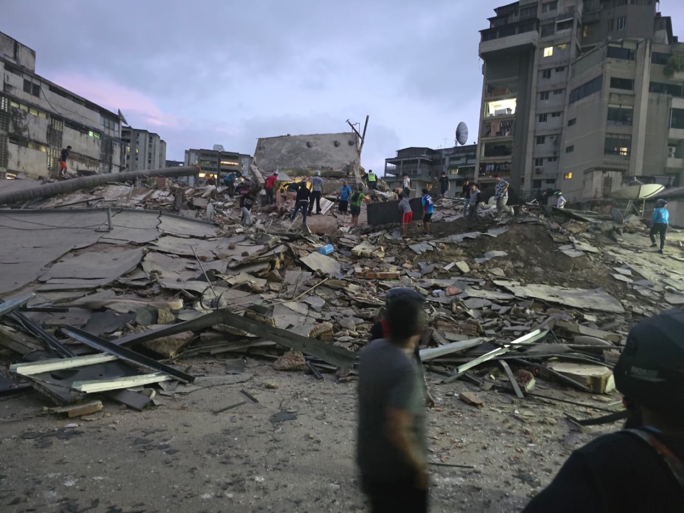 Escombros de un edificio colapsado al anochecer