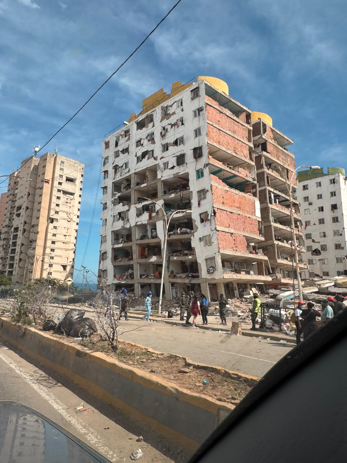 Edificio residencial de apartamentos severamente dañado, con cuadrillas en la calle